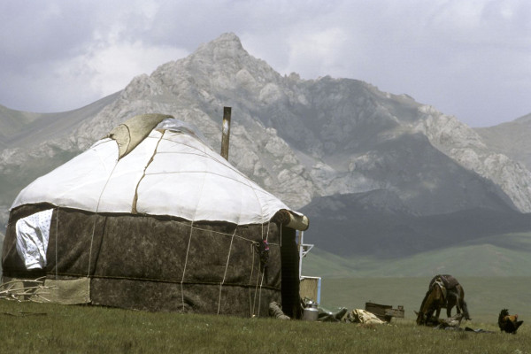 Jurt in front of snow capped mountains